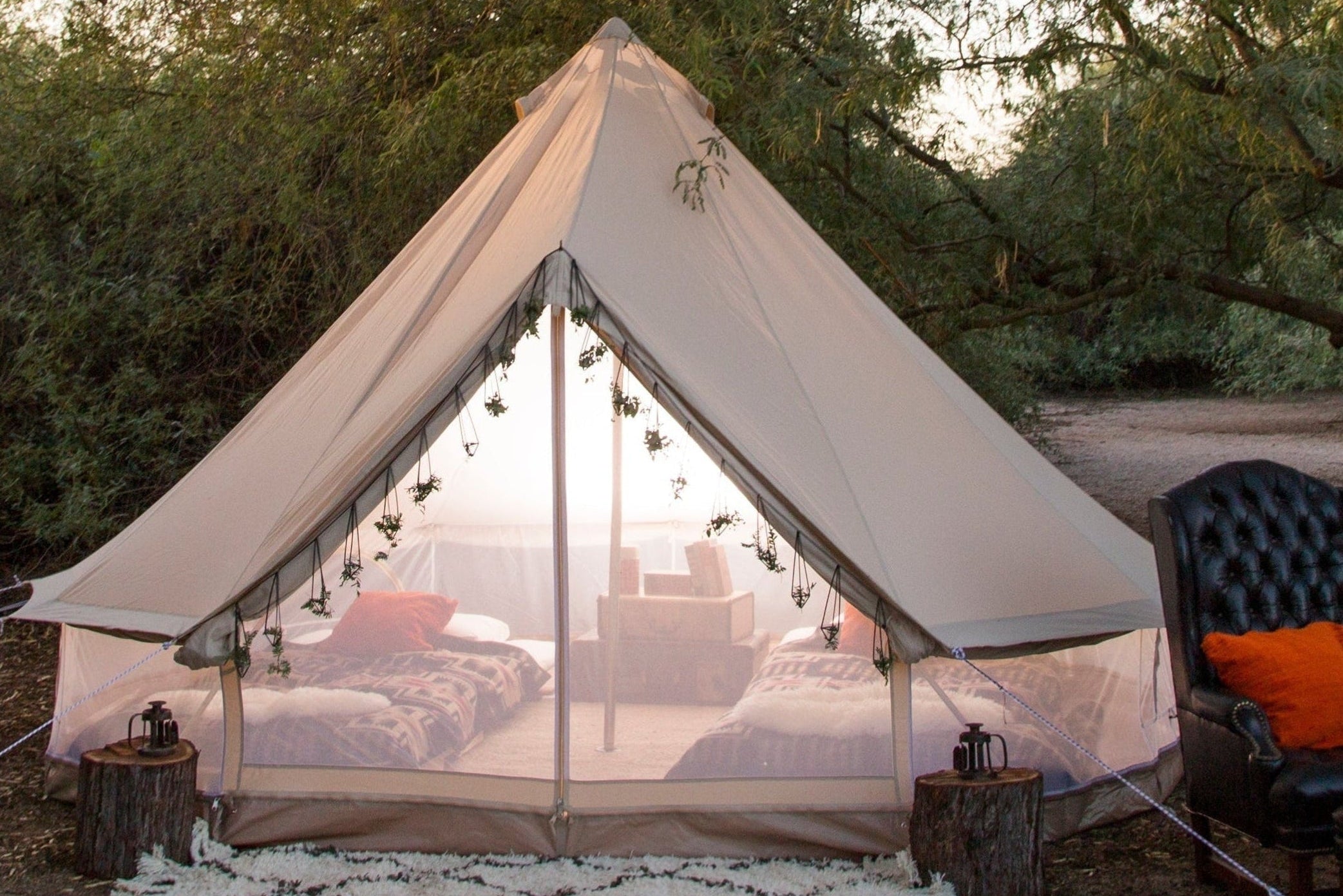 Camping tent with outdoor furniture and decor in a natural setting