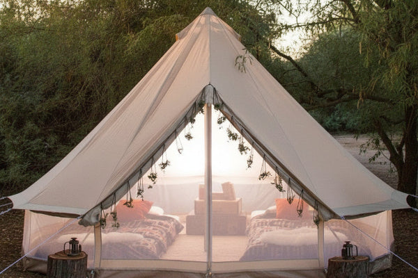 Camping tent with outdoor furniture and decor in a natural setting