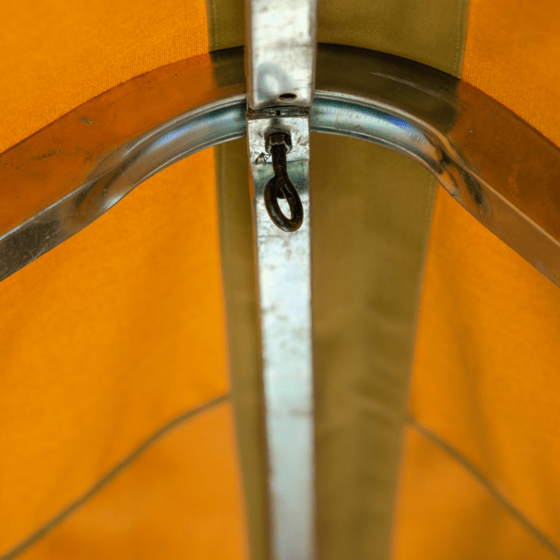 Close-up of a metal hook on a steel rail on ceiling of beige tent
