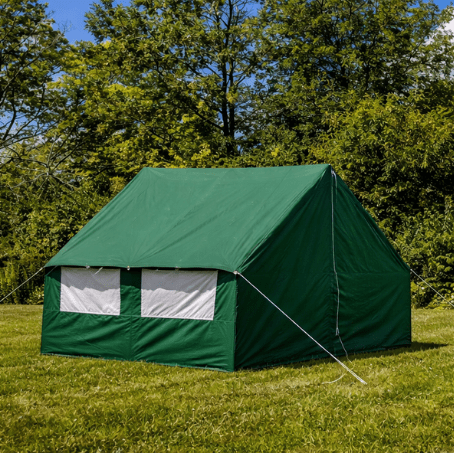 Green wall tent in a grassy area with trees and blue sky