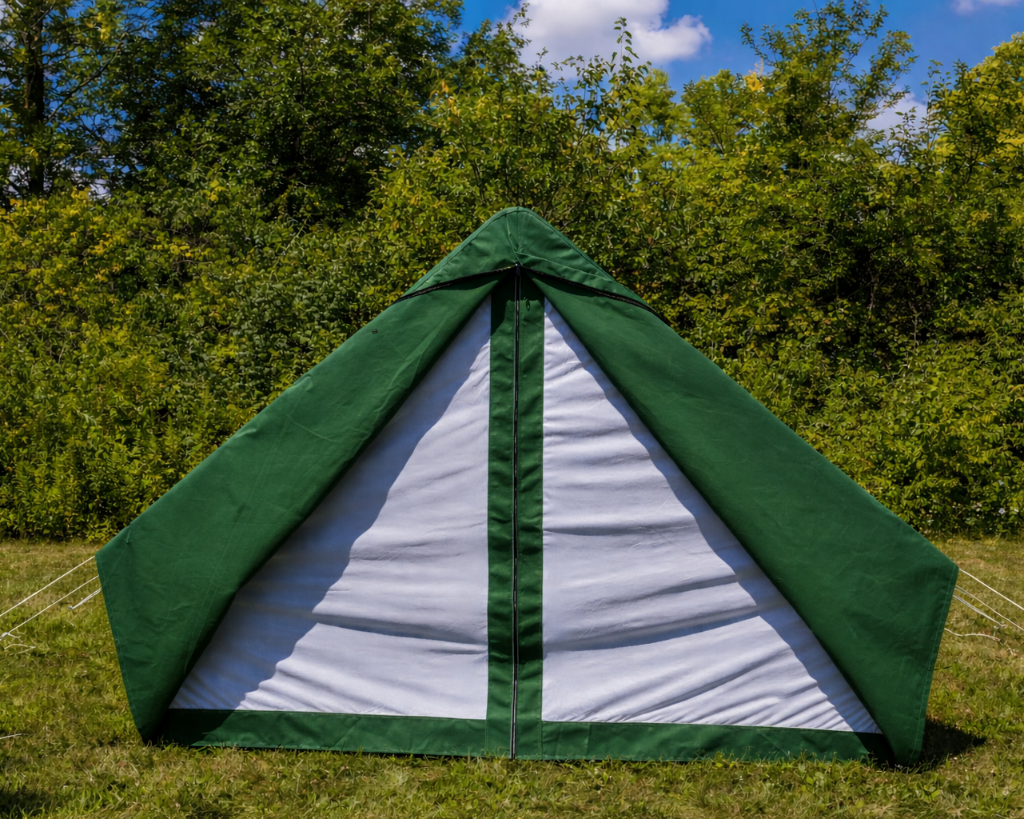 Green and white tent set up in a grassy area with trees in the background