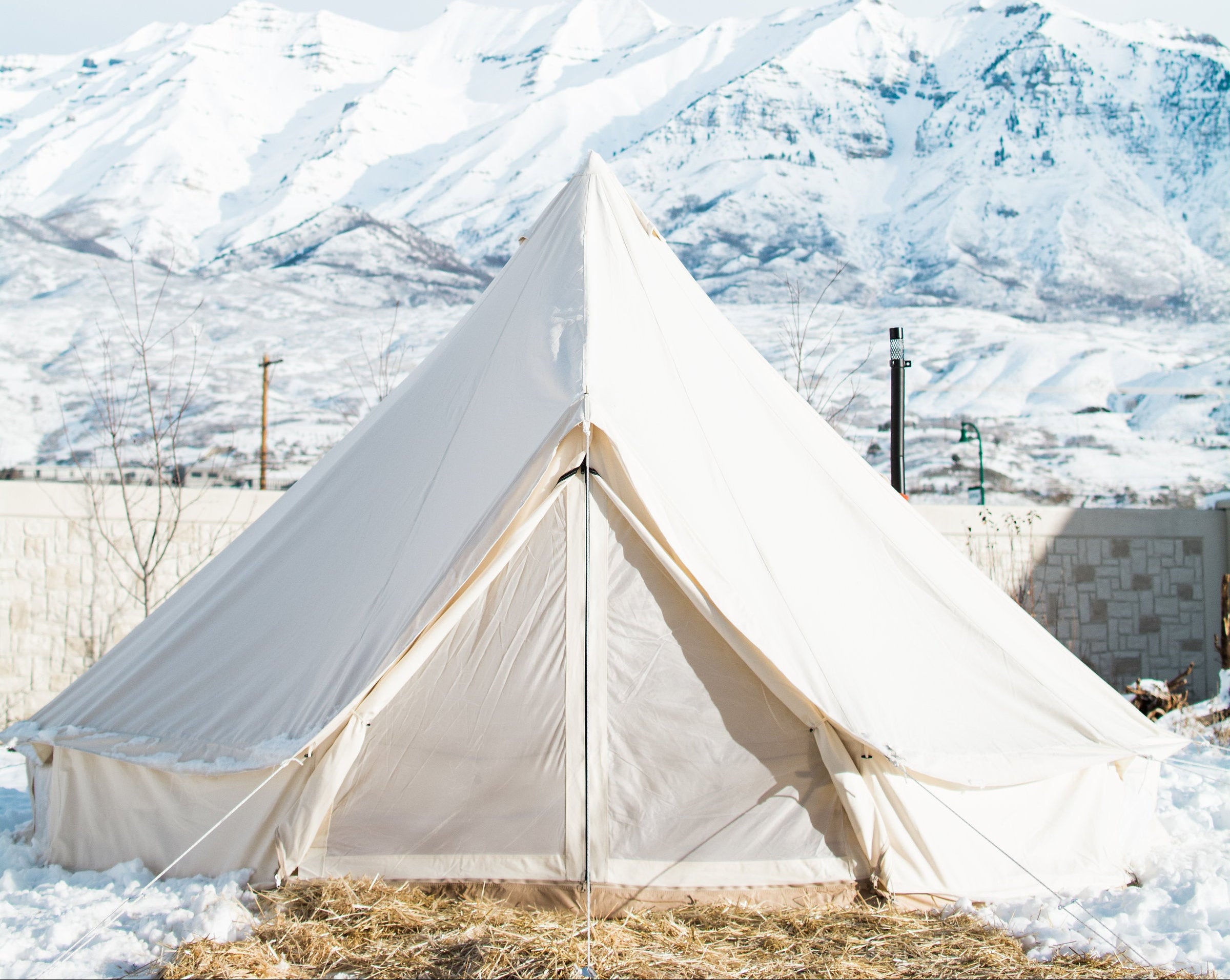 White tent in a snowy landscape with mountains in the background