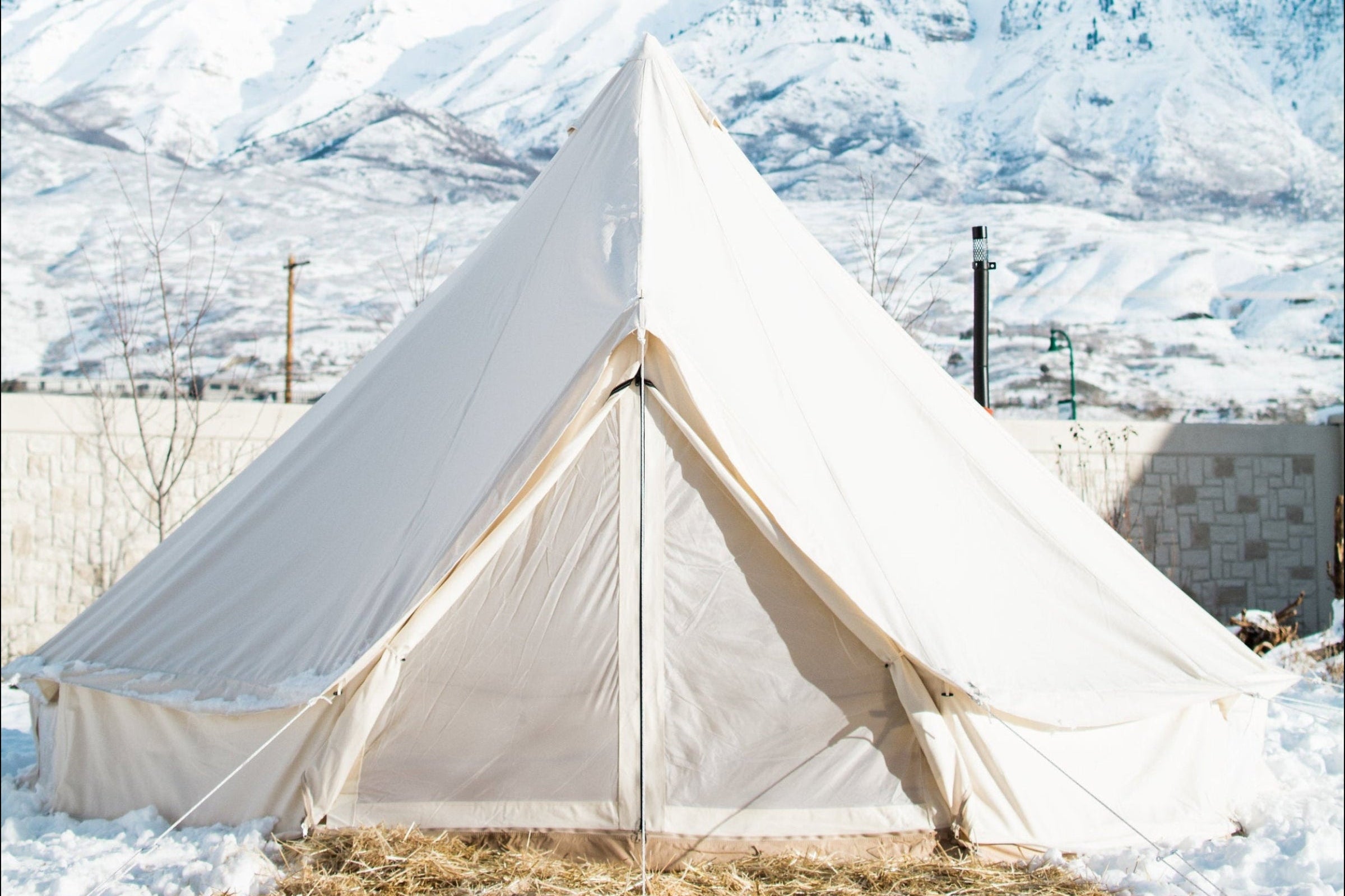 White tent in a snowy landscape with mountains in the background