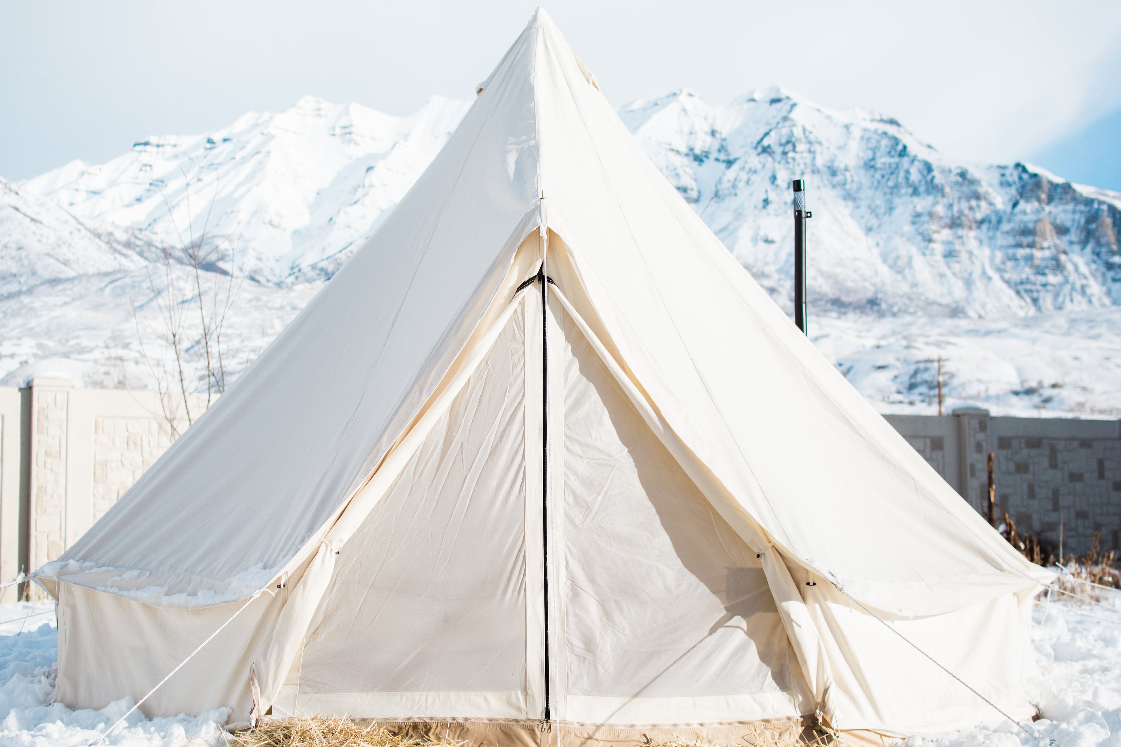White tent in a snowy landscape with mountains in the background
