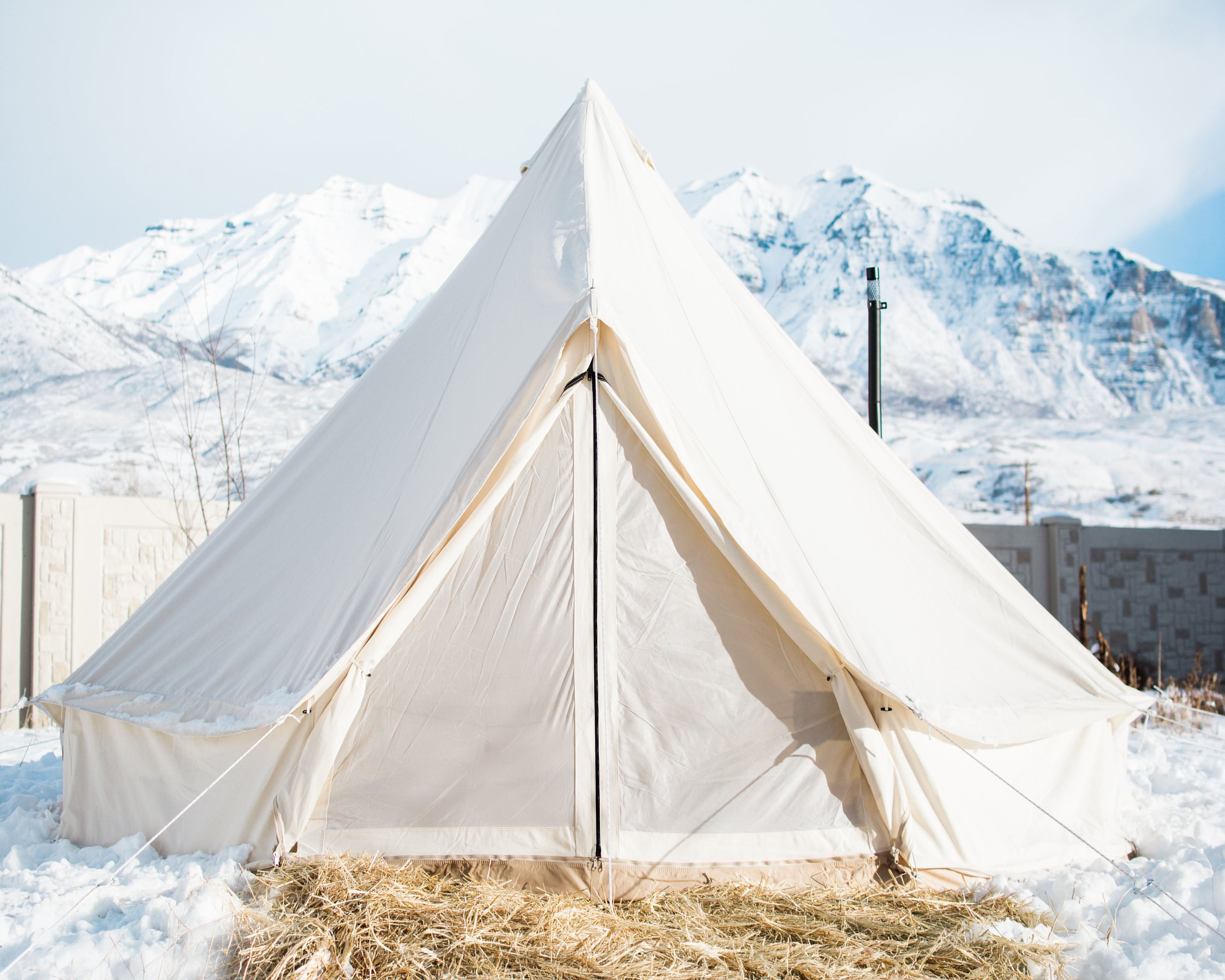 White tent in a snowy landscape with mountains in the background