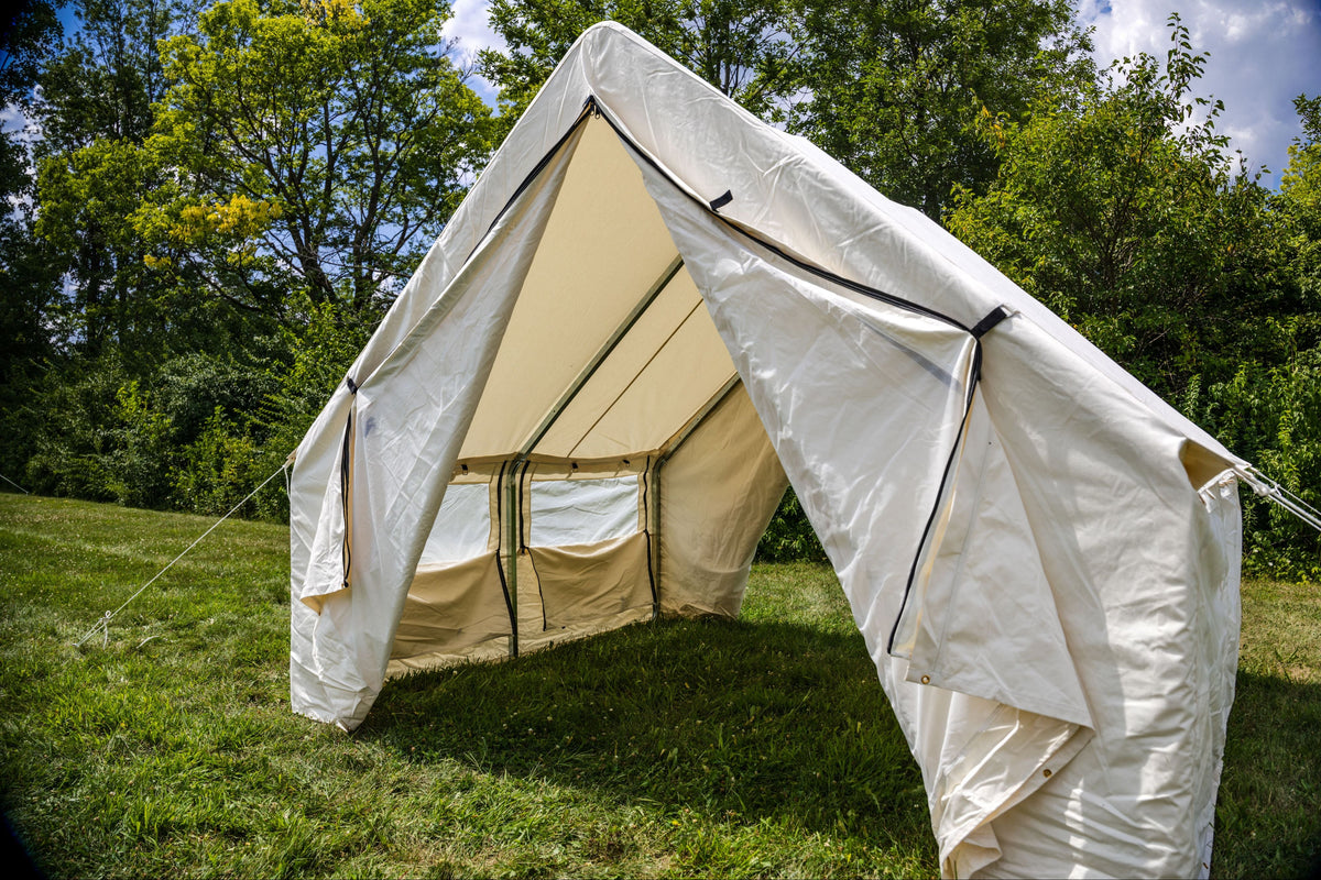 Beige bell tent with white flysheet on grassy area with trees in the background