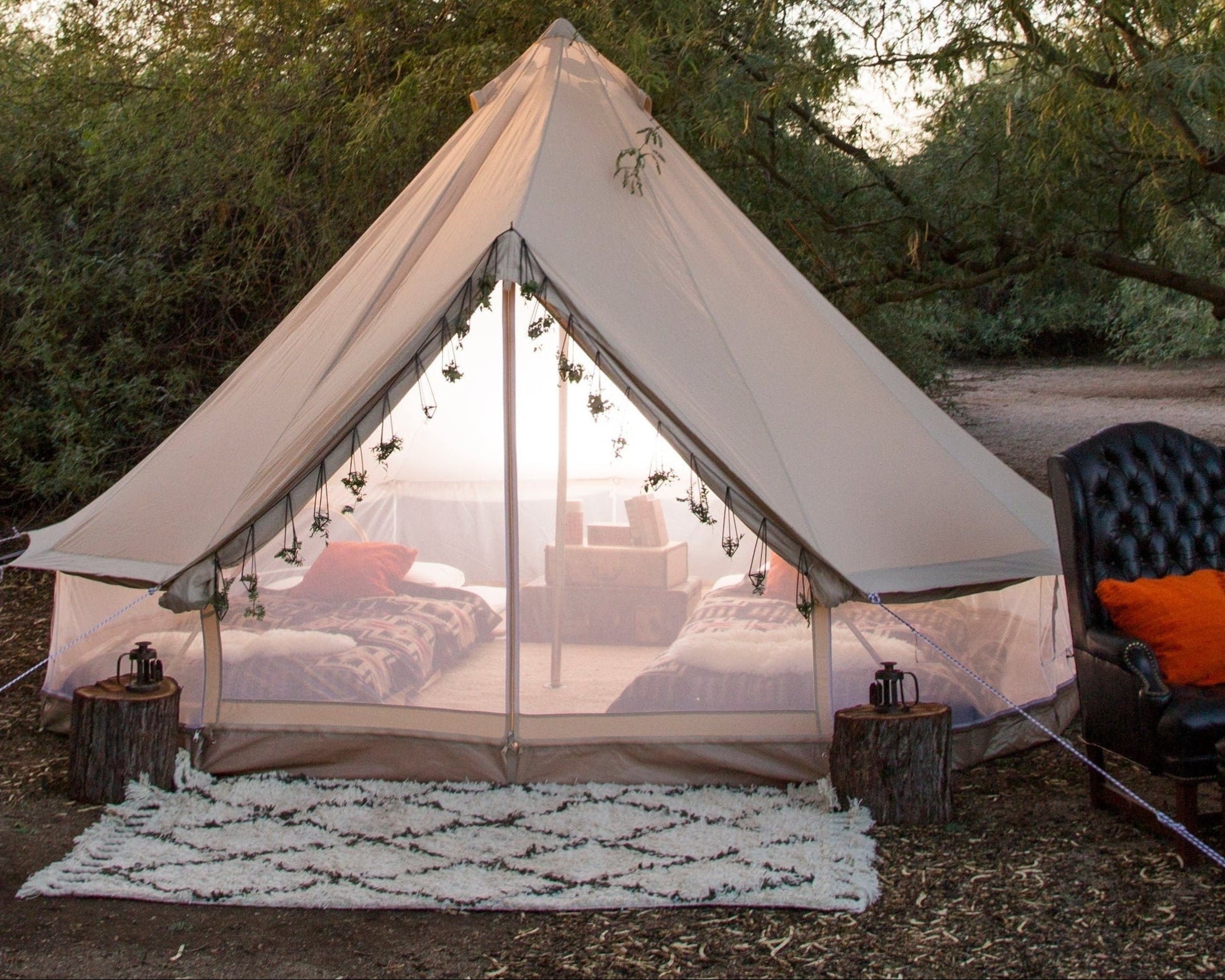 Camping tent with outdoor furniture and decor in a natural setting