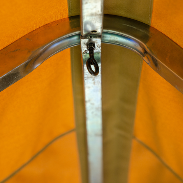 Close-up of a metal hook on a steel rail on ceiling of beige tent