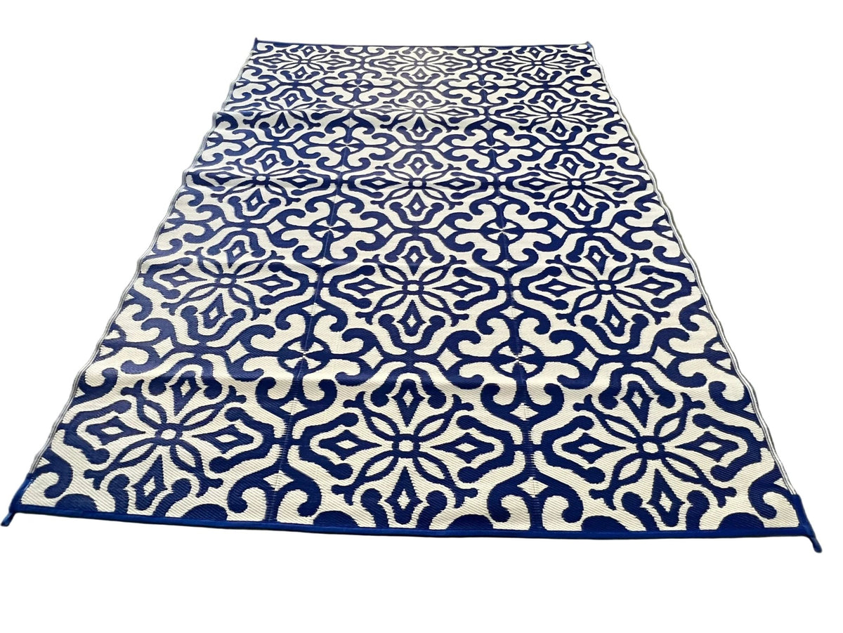Blue and white patterned rug on a concrete floor