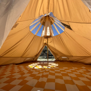 Inside view of a beige tent with a yellow checkered rug