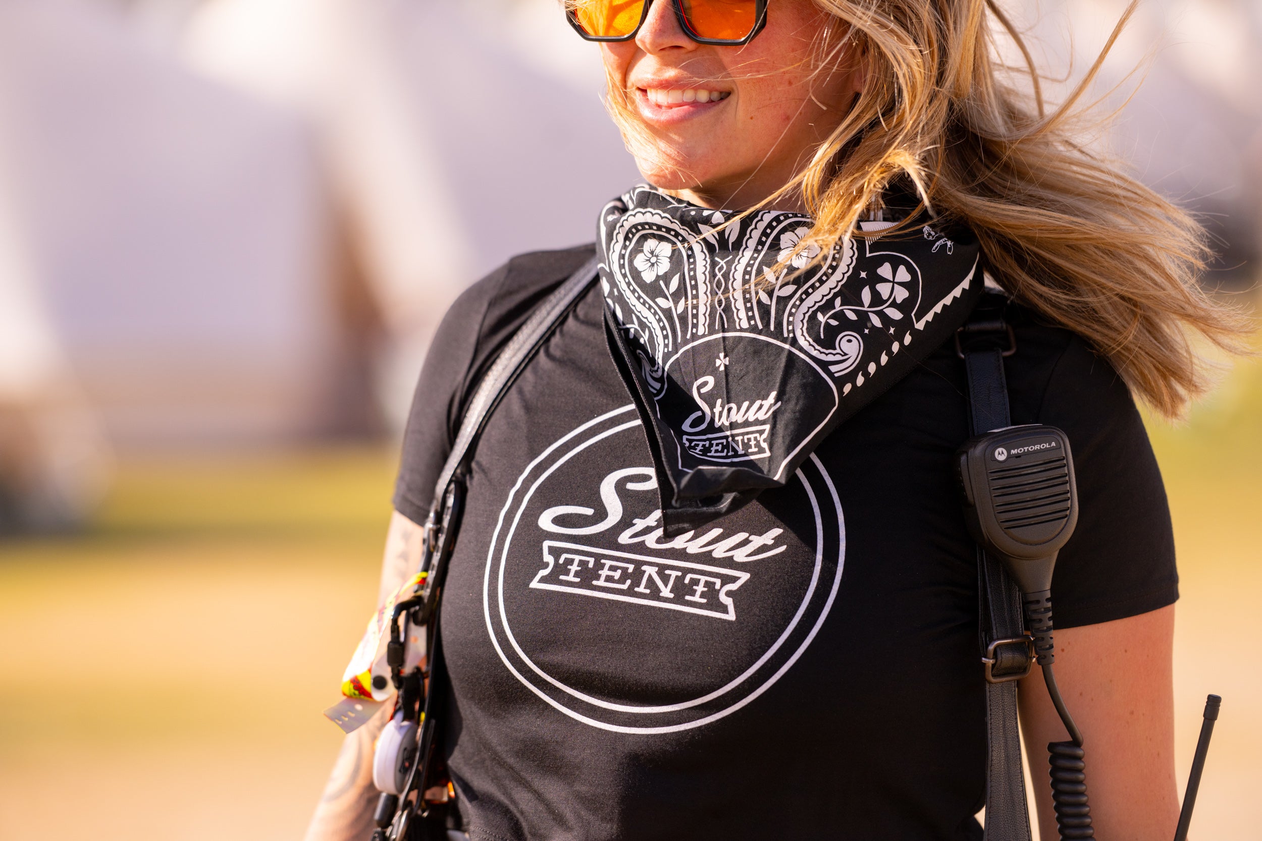 Person wearing a black t-shirt with 'Stud Tvent' logo, sunglasses, and bandana in an outdoor setting.