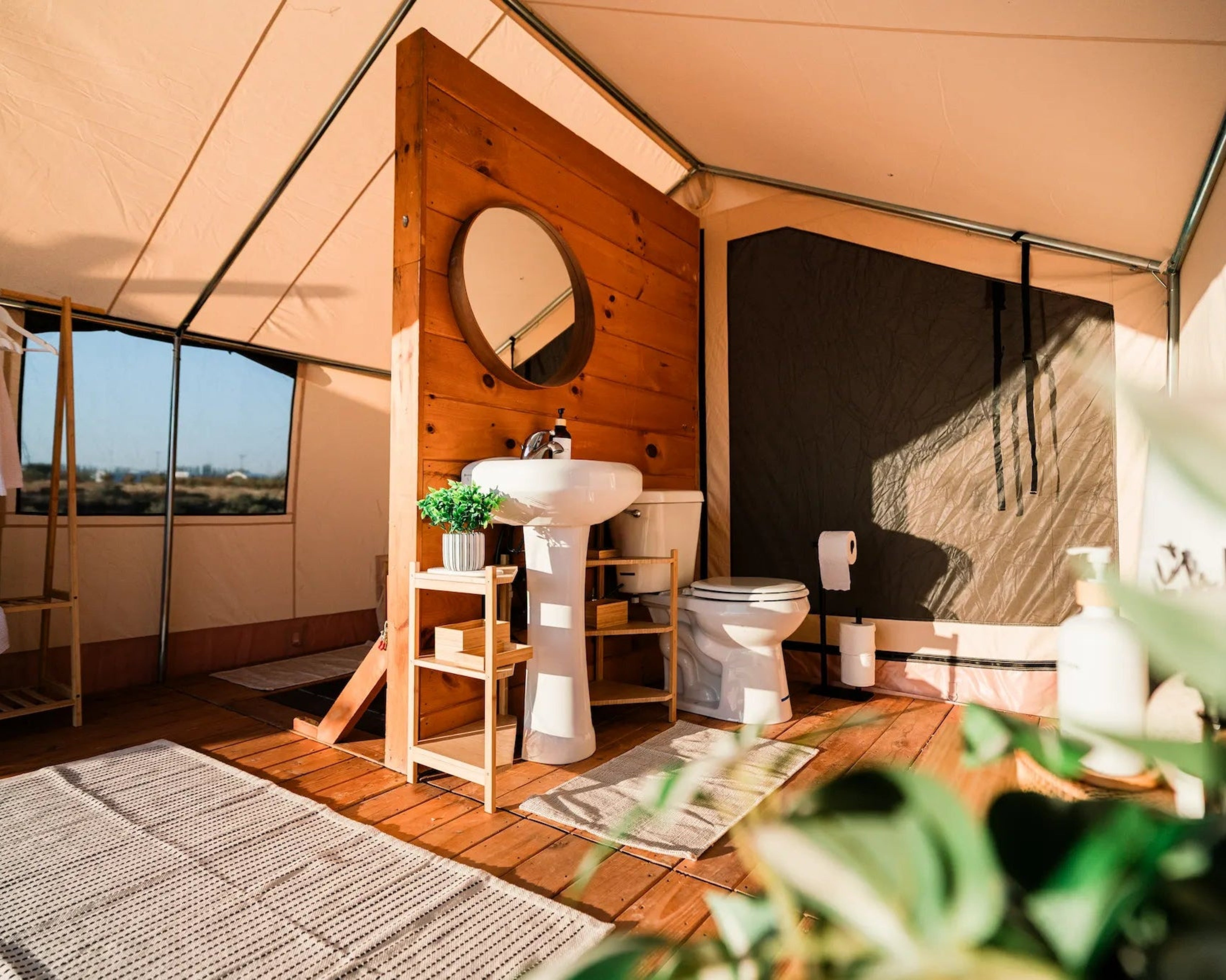 Interior of a glamping tent with wooden walls, sink, and decor.