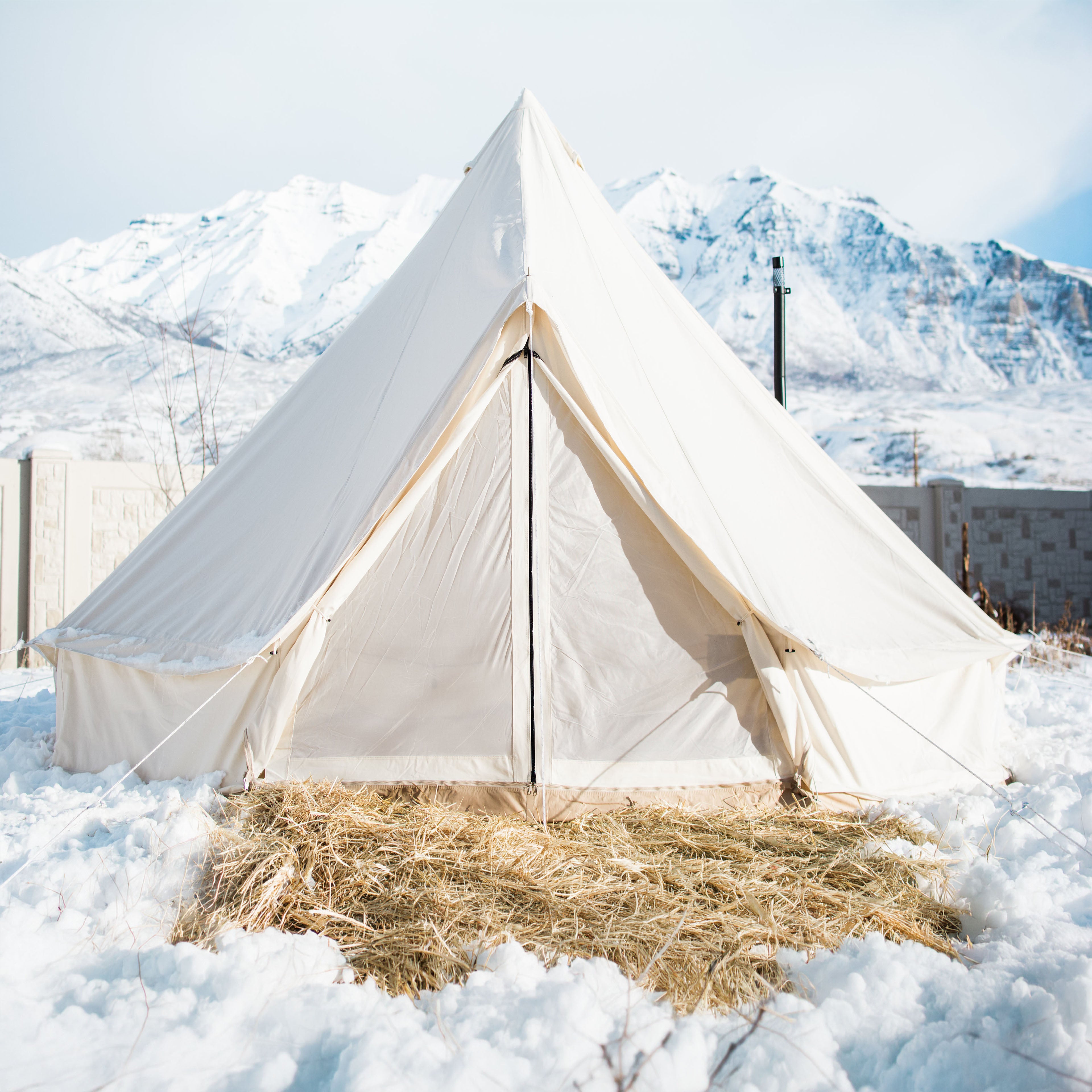 White tent in a snowy landscape with mountains in the background