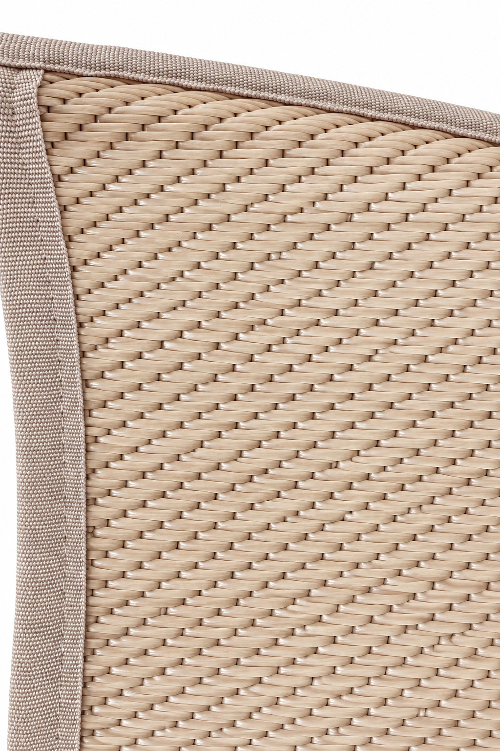 Close-up of a woven natural fiber mat, likely rattan or wicker, with a stitched fabric border in a muted pinkish-beige color.