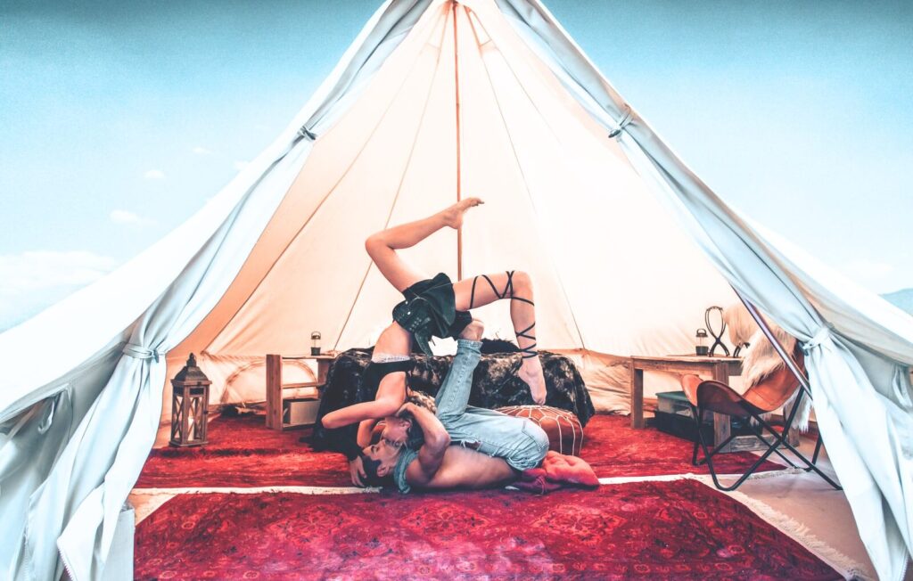 Couple practicing yoga inside a Stout Bell Tent sanctuary for backyard wellness