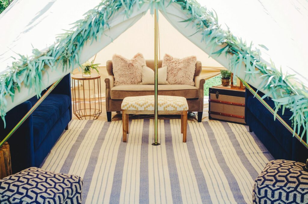 Luxury outdoor office lounge inside a Stout Pro Bell Tent with a leather couch