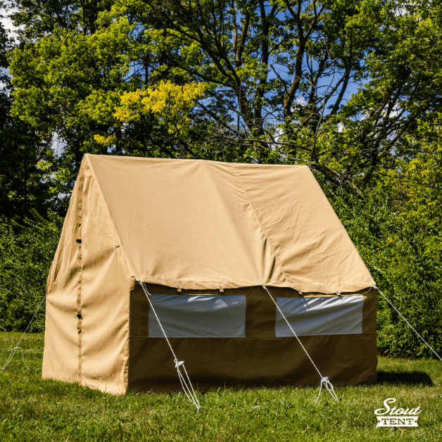 Side view of tan canvas wall tent by Stout Tent with screened windows and front door fastened closed