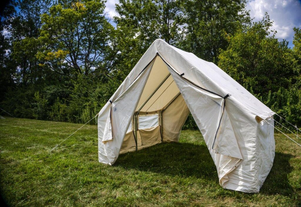 White Stout canvas wall tent with screen windows and open door