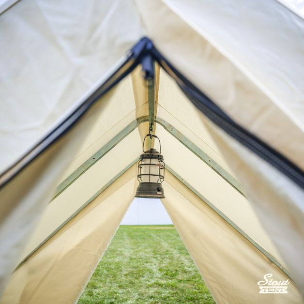 Close-up of A-frame door on white canvas wall tent by Stout Tent showing double zipper for canvas and mesh screen layers