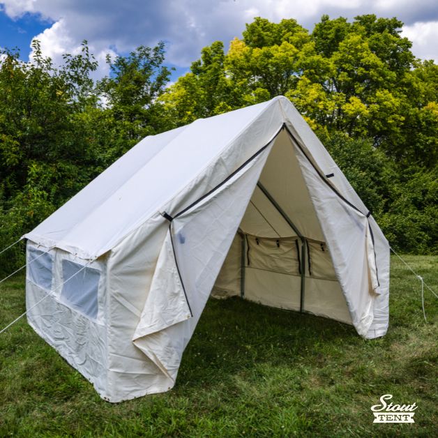 Side view of white canvas wall tent by Stout Tent showing screened windows with rolled-up canvas flaps