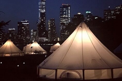 Luxury Stout Bell Tents at a professional glamping resort on Governors Island with the New York City skyline in the background.